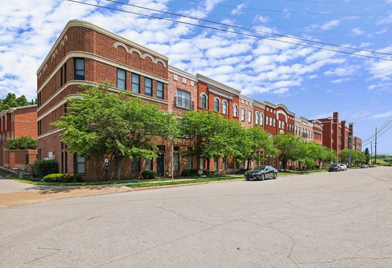 Front view of a large, multi-story brick building with modern architectural design.