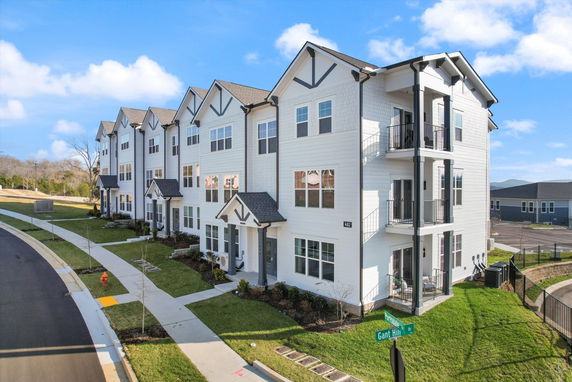 Front view of a multi-story townhouse complex with individual entrances.