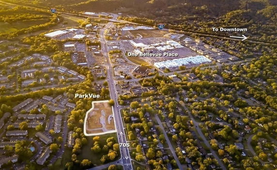 Aerial panoramic view of a suburban area with roads, buildings, and green spaces.