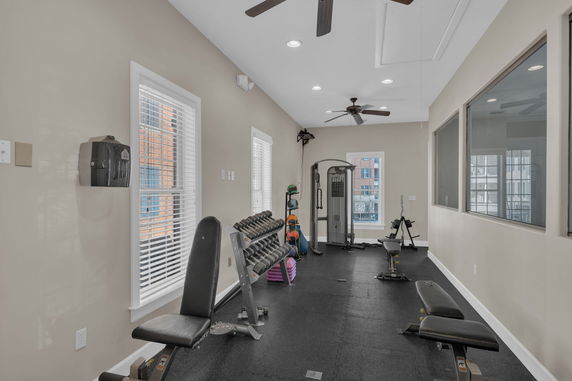 Indoor gym area with exercise equipment and weights.