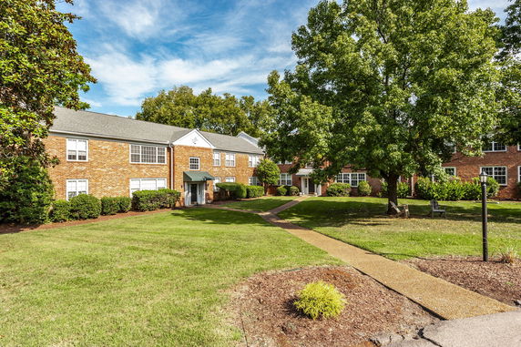Front view of a two-story brick building with greenery and pathways.