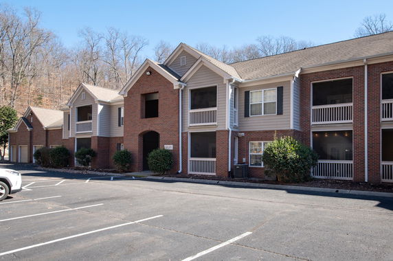 Front view of a multi-story building with brick facade and balconies.