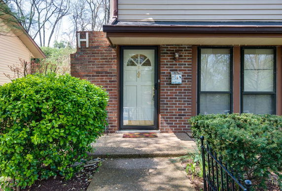 Front view of a single-story house with a glass door and brick exterior.