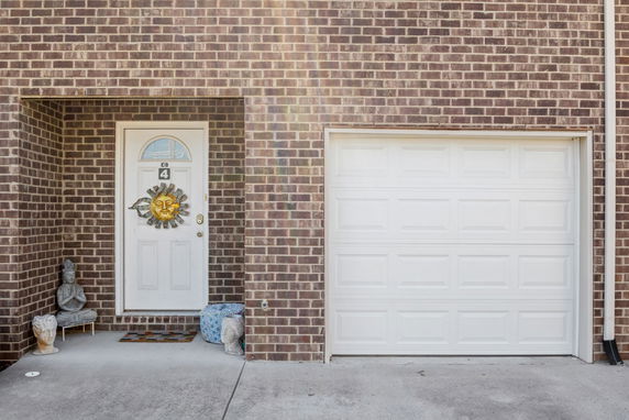 Front view of a house with a brick exterior and a white garage door.