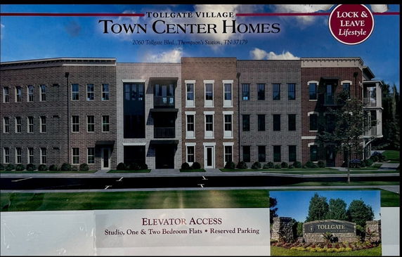Front view of a multi-story brick building with large windows.