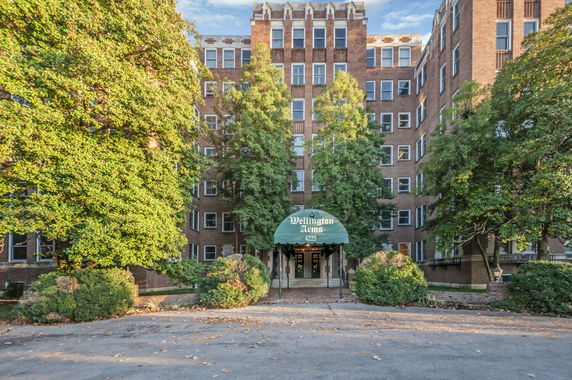 Front view of a multi-story brick building with a canopy entrance.