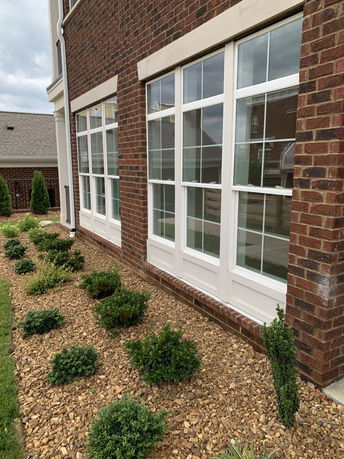 Side view of a building with large windows and a brick exterior.