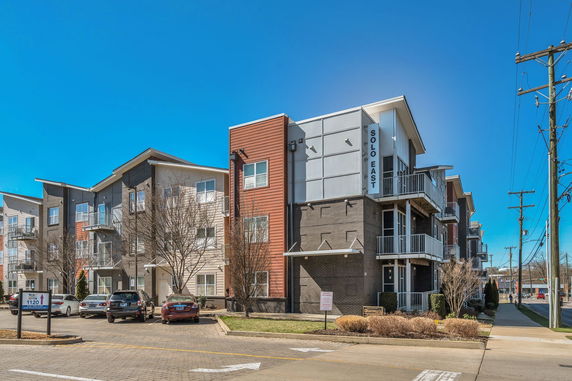 Front view of a multi-story apartment building with balconies and modern design.