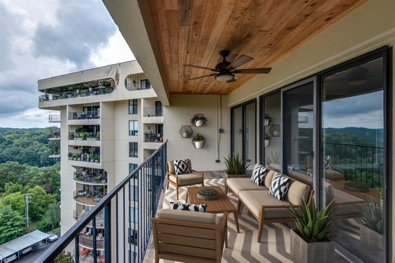 Outdoor balcony with modern furniture and view of adjacent building.
