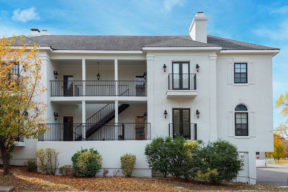 Front view of a two-story building with balconies and staircases.