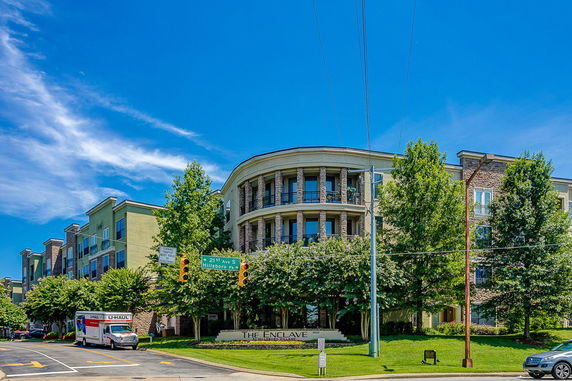 Front view of a multi-story residential building with balconies and stone columns.
