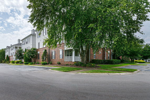 Front view of a multi-story building with brick and white siding.
