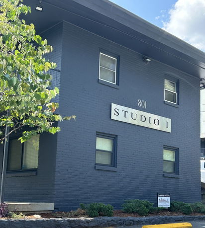 Front view of a two-story building with a dark exterior marked 'Studio I'.