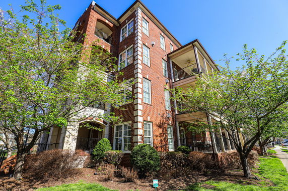 Front view of a multi-story brick apartment building with balconies.