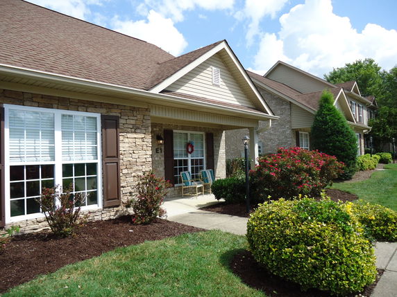 Front view of a house with a stone facade and gabled roof.