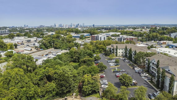 Panoramic view of a cityscape with residential and commercial buildings surrounded by trees.