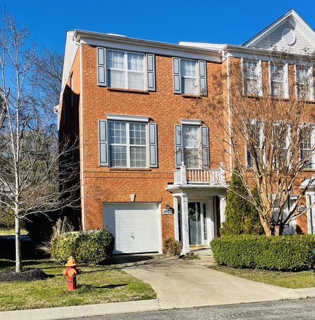 Front view of a three-story brick house with a garage.