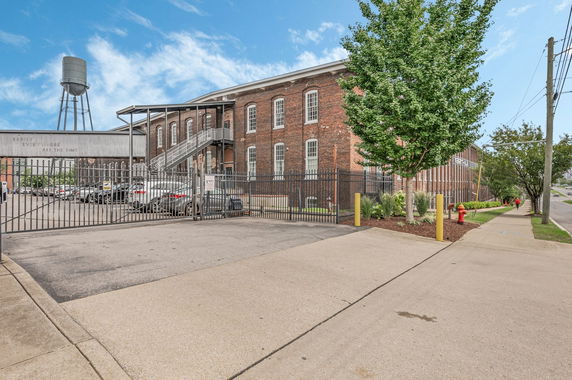 Front view of a large brick industrial building with multiple windows and an external staircase.