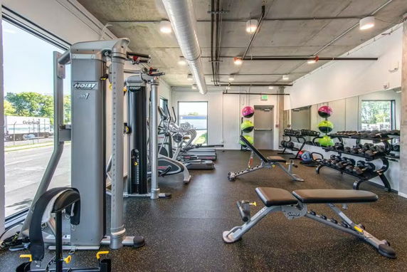 Interior view of a gym with exercise equipment and weights.