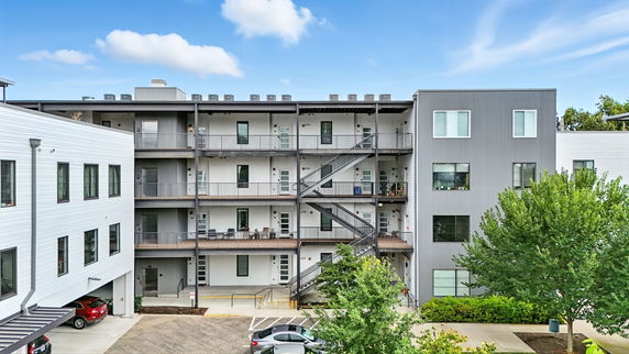 Front view of a multi-story building with external staircases and balconies.