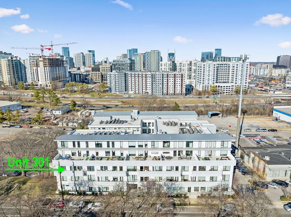 Aerial view of a multi-story residential building with a cityscape of skyscrapers in the background.
