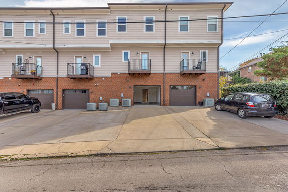 Front view of multi-story townhouses with garages.