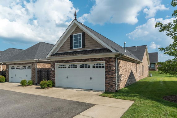 Front view of a brick house with a double garage and a steep roof.