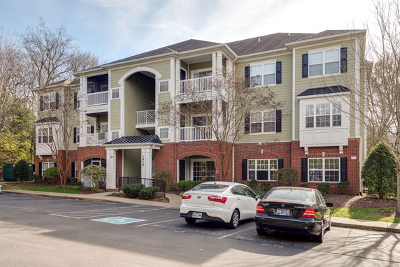 Front view of a three-story apartment building with a brick and siding exterior.