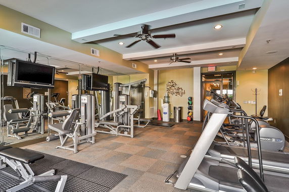Indoor gym area with exercise equipment and mirrors.
