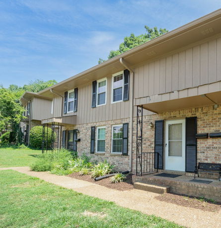 Front view of a two-story townhouse with brick and siding exterior.