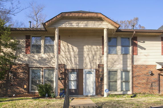 Front view of a two-story house with brick and siding exterior.