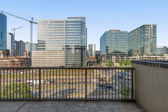 View from a balcony overlooking a cityscape with tall office buildings.