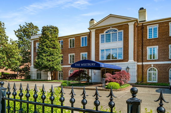 Front view of a multi-story brick building with a large entrance canopy.