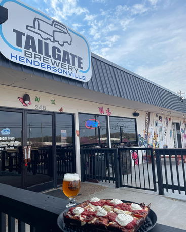 Front view of a brewery with outdoor seating area and signage.
