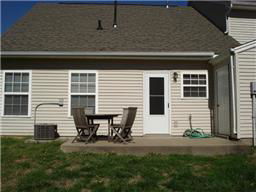 Rear view of a house with a patio and outdoor seating.