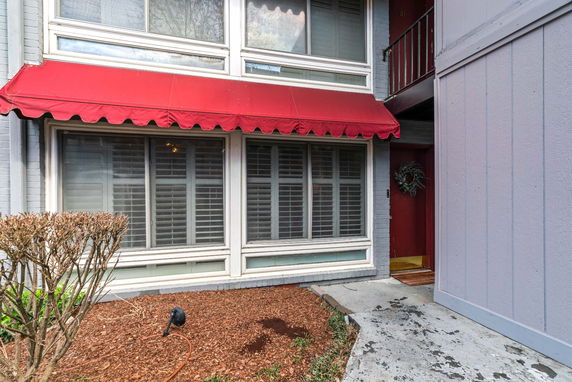 Front view of a building with large windows and a red awning.